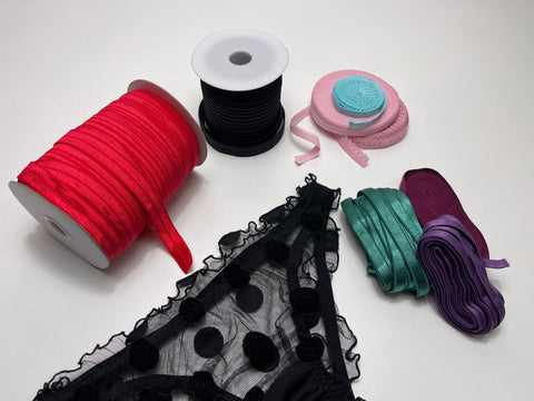 Elastic rolls, stretch lace, and sewing tools arranged for DIY underwear project, showing essential supplies for lingerie making