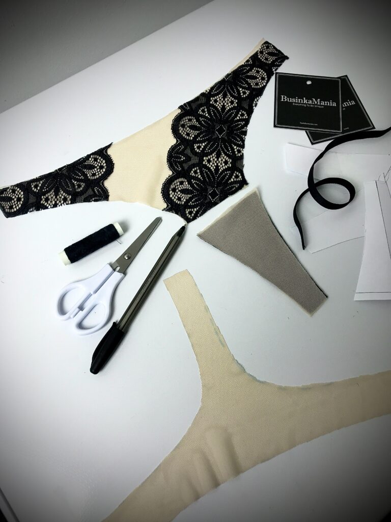 Lingerie sewing project with lace fabric, gusset piece, scissors, and thread showing panty construction process