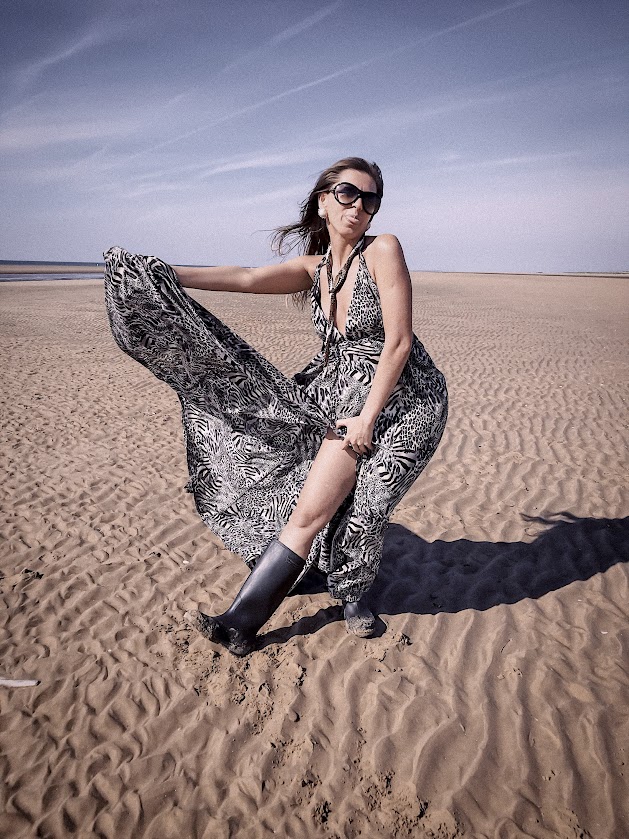 Woman in flowing dress on a quiet beach, symbolising the freedom and peace of building an introvert-friendly sewing business.
