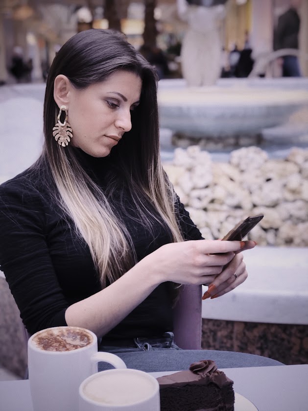 Woman planning Instagram sewing content on phone with coffee and cake, part of growth story from 2K to 16K followers