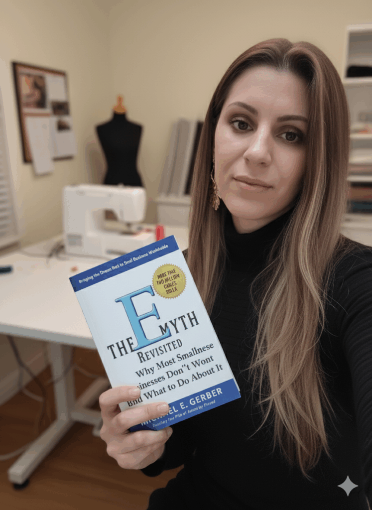 Woman holding The E-Myth Revisited by Michael E. Gerber, a key book for balancing sewing passion and business growth