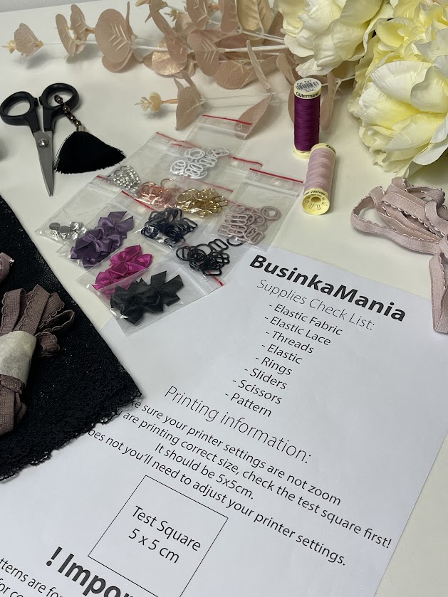 Flat lay of sewing supplies, elastics, rings, threads, and printed BusinkaMania checklist for assembling the Jade crop top pattern.