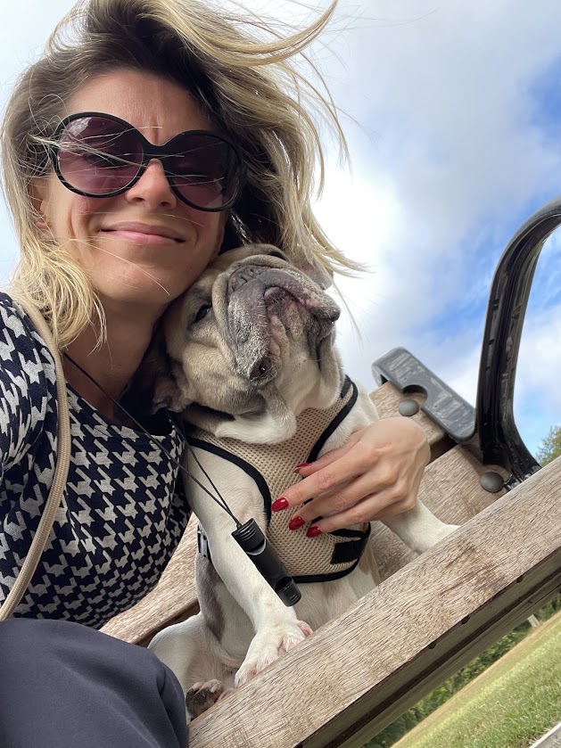Woman smiling with her French bulldog before starting a DIY lingerie sewing project at home