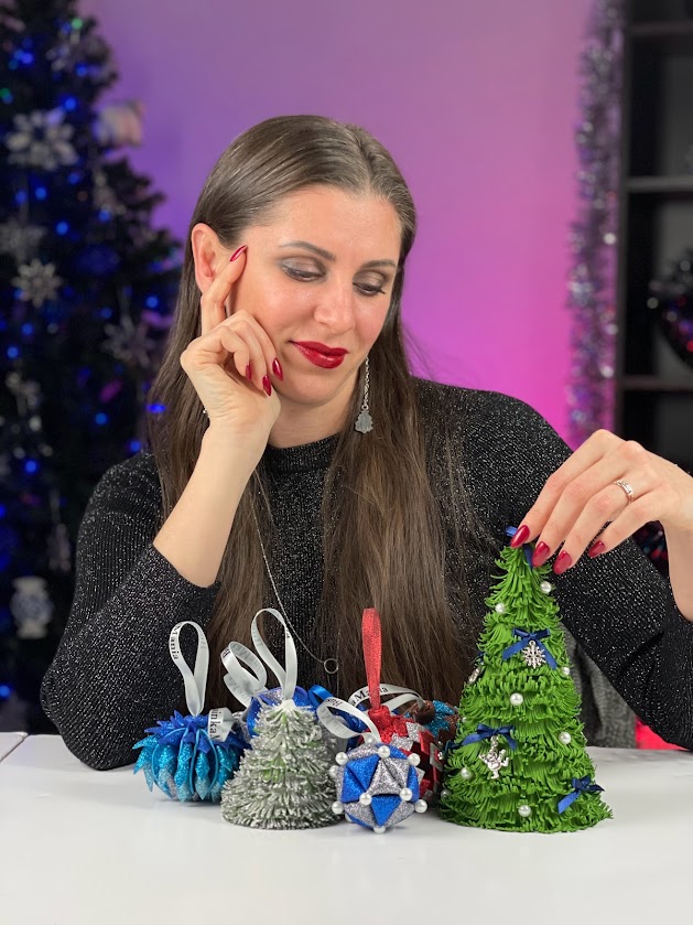 Woman smiling at handmade felt Christmas trees and ornaments, featured in DIY Christmas gifts for women craft ideas article.