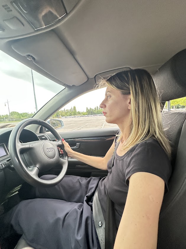 Woman learning to drive a manual car, showing the challenge of starting new skills like sewing lingerie at home