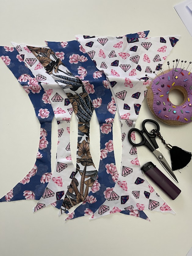 Pinned fabric pieces for thong panties showing crotch seam alignment and sewing tools for Step 2 underwear tutorial.