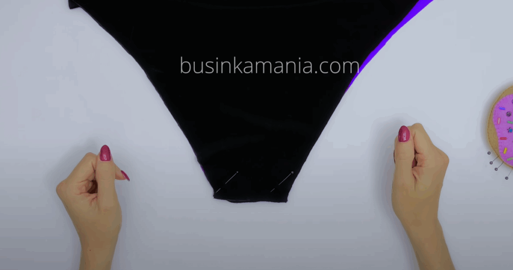 Hands aligning black swimsuit fabric layers to sew the crotch seam for Swimsuit Jadore beginner sewing project.