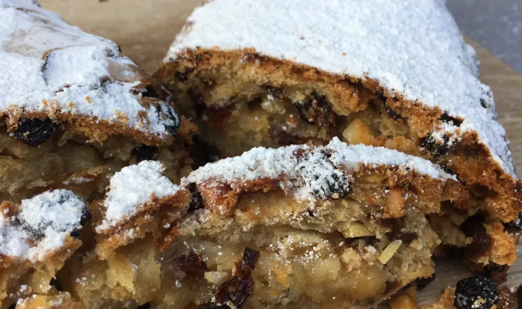Close up of a store bought Stollen dusted with icing sugar, used to explain handmade pricing and customer comparison in the article.