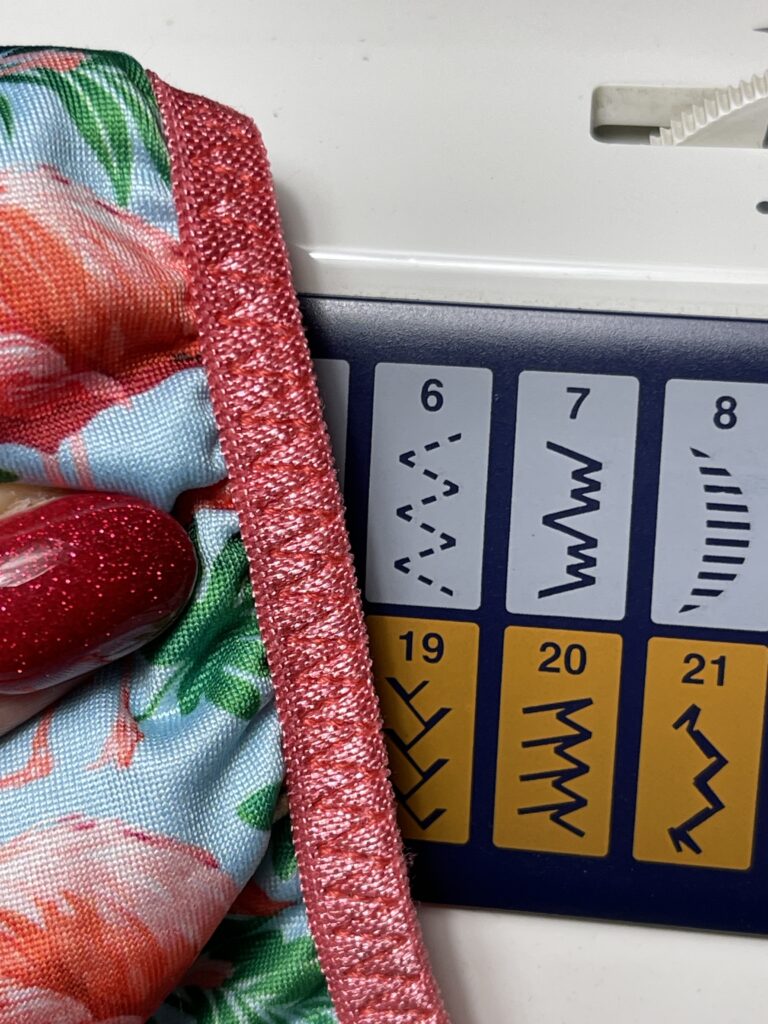 Close-up of fold-over elastic stitched to floral fabric using elastic stretch stitch for underwear finishing
