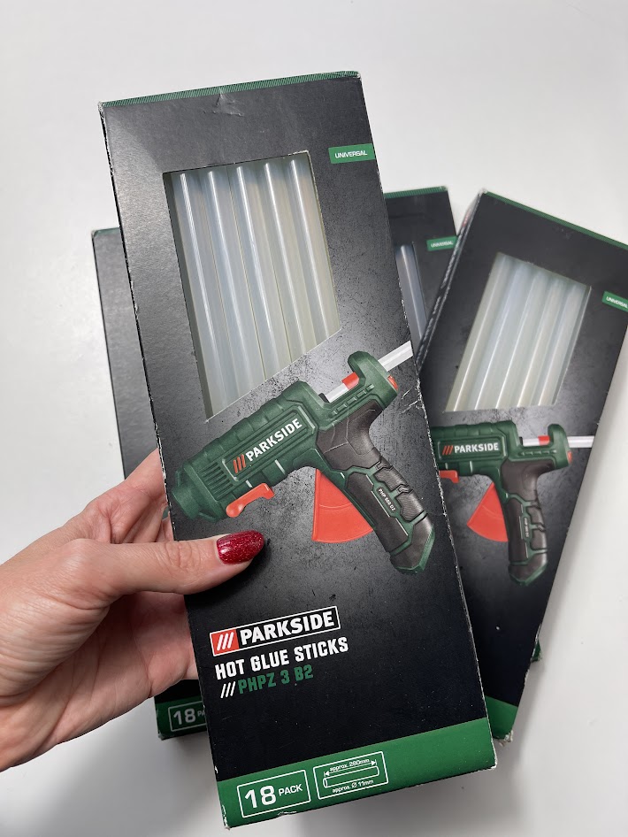 Hand holding Parkside hot glue sticks packaging with large diameter sticks for heavy duty glue gun projects