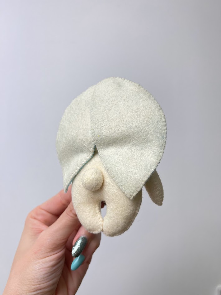 Round felt circle stitched near edge and partially gathered to form small 3D tail for handmade plush animal tutorial