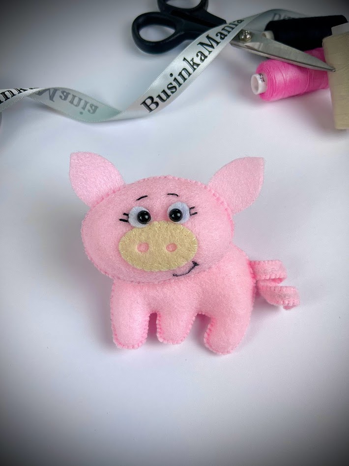 Pink felt pig plush with curly tail, wire inside technique for shaping flexible felt animal tails in DIY craft project