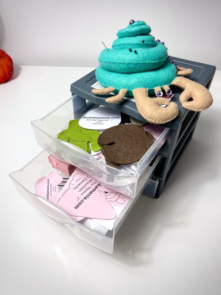 Stacked plastic drawers filled with mixed felt pattern pieces showing messy craft sewing pattern storage system